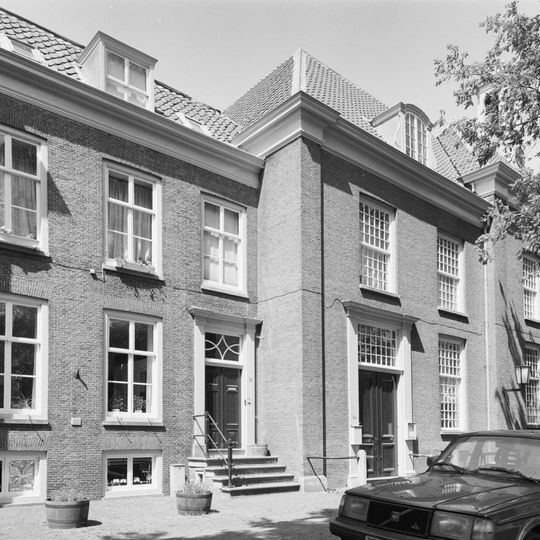 Pand met inspringende sobere lijstgevel en stoep, tegenhanger van nr 10