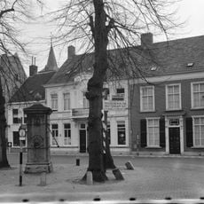 Herenhuis uit de eerste helft van de 19e eeuw, met dwars zadeldak en lijstgevel, ingang met versierd bovenlicht, hoofdgestel met guirlande en voluutvormige consoles