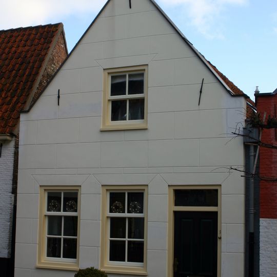 Gepleisterd pand, met afgeknotte gevel