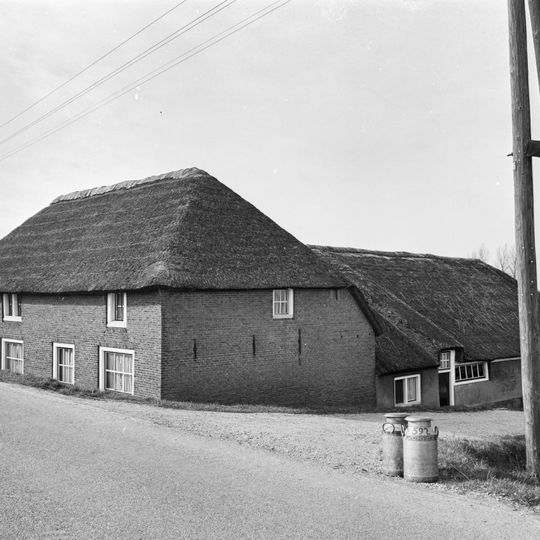 Boerderij, waarvan het woongedeelte dwars voor de stal is gebouwd. Woonhuis onder rieten schilddak. Vensters met 12-ruitsschuiframen