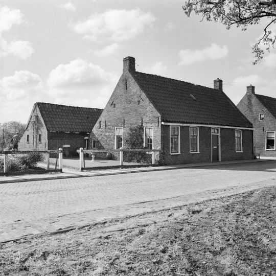 Pand onder zadeldak tussen topgevels met vlechtingen en kleine lichtopeningen