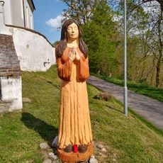 Dřevěná socha před kostelem v Doudlebech